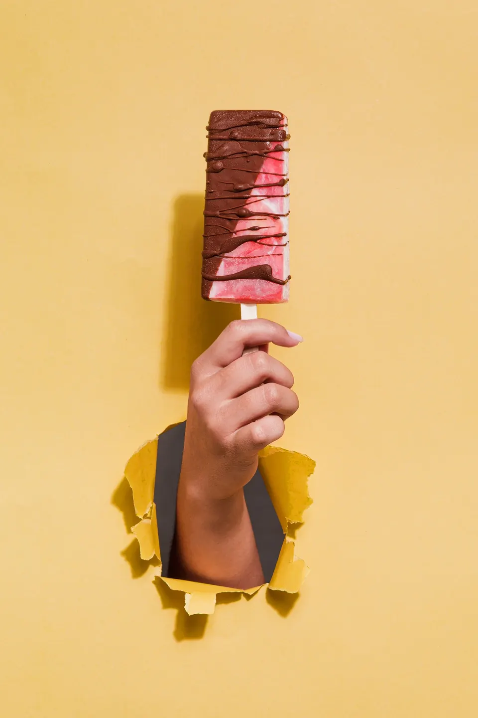 Paleta cremosa IKE nivel La Tranqui con medio baño de chocolate, sobre fondo amarillo